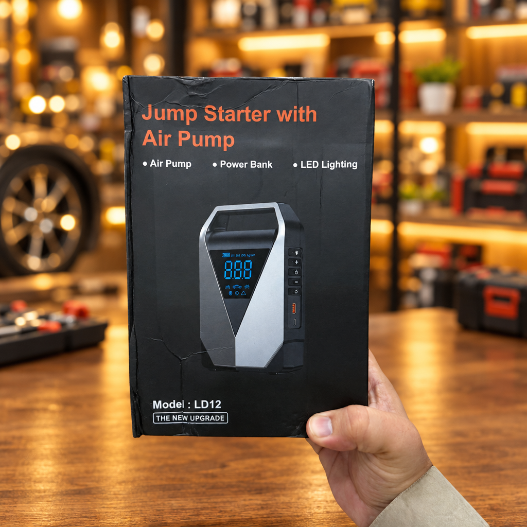 LD12 Jump Starter held in hand with red black jump clamps attached green LED indicator - Showroom